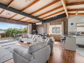 A living room with sofa and kitchen area at Whitianga