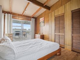 A bedroom with a bed and sliding doors at Whitianga