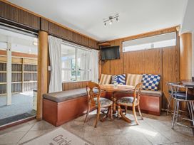 A snug with a table and seating area at Whitianga