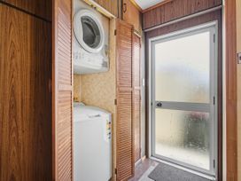 A laundry room with washing machine and dryer at Whitianga