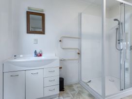 A bathroom with a sink and shower at Tides and Time Bach - Ahipara Holiday Home Kaitaia