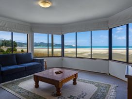 A living room with a coffee table and sofa at Tides and Time Bach - Ahipara Holiday Home Kaitaia