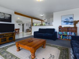 A living room with a sofa and coffee table at Tides and Time Bach - Ahipara Holiday Home Kaitaia