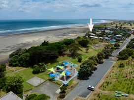 An aerial view of a beach and park area at Tides and Time Bach - Ahipara Holiday Home Kaitaia