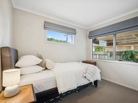 A bedroom with a bed and a lamp at Martinborough Holiday Home in Martinborough