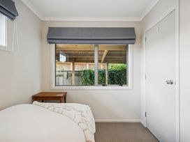 A bedroom with a bed and a table at Martinborough Holiday Home in Martinborough