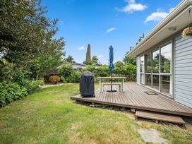 An outdoor space with a deck, table, and umbrella at Martinborough Holiday Home, Martinborough
