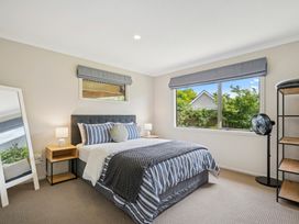 A bedroom with a bed and a mirror at Martinborough Holiday Home in Martinborough