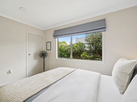 A bedroom with a bed and fan at Martinborough Holiday Home in Martinborough