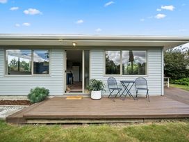 A house with a deck, table and chairs at Martinborough Holiday Home in Martinborough