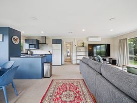 A living room with a kitchen and refrigerator at Martinborough Holiday Home, Martinborough