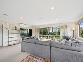 A living room with a sofa and television at Martinborough Holiday Home Martinborough