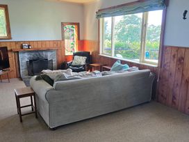 A living room with a couch and armchair at Salt and Siren - Mangawhai Heads Holiday Home