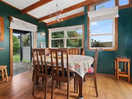 A dining area with a table and chairs at Salt and Siren - Mangawhai Heads Holiday Home 