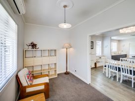 A living room with an armchair and a shelf at Deco-licious - Napier Holiday Home, Napier
