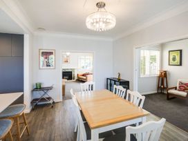 A dining room with a table and chairs at Deco-licious - Napier Holiday Home, Napier