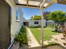 A garden with a path, plants, and a house at Deco-licious - Napier Holiday Home, Napier