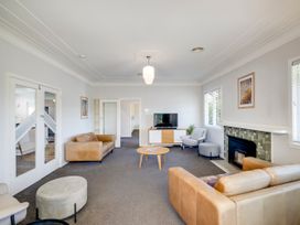 A living room with sofas, coffee table, and a TV at Deco-licious - Napier Holiday Home, Napier