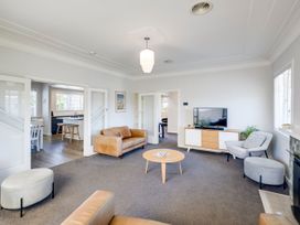 A living room with a couch and coffee table at Deco-licious - Napier Holiday Home in Napier