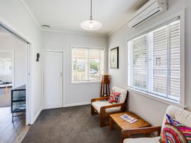 A living room with armchairs and a coffee table at Deco-licious - Napier Holiday Home, Napier