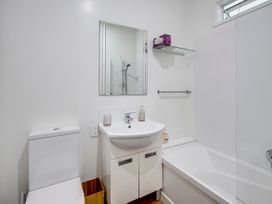 A bathroom with a sink, toilet, shower, and bathtub at Deco-licious - Napier Holiday Home in Napier