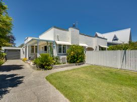 An outdoor view of a house with a driveway and garden at Deco-licious - Napier Holiday Home, Napier