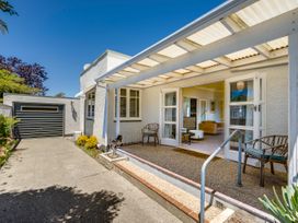 An outdoor patio area with sliding doors at Deco-licious - Napier Holiday Home, Napier