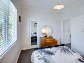 A bedroom with a bed and a dresser at Deco-licious - Napier Holiday Home Napier