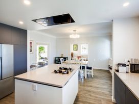 A kitchen with a refrigerator, stove, and dining area at Deco-licious - Napier Holiday Home, Napier