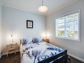 A bedroom with a bed and bedside tables at Deco-licious - Napier Holiday Home Napier