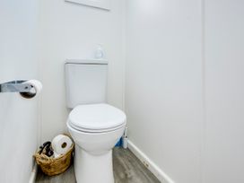 A toilet and toilet paper holder in a bathroom at Deco-licious - Napier Holiday Home, Napier