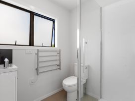 A bathroom with a shower, toilet, and sink at Mania Views Waipu