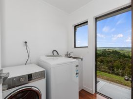 A laundry room with a washing machine and dryer at Mania Views Waipu