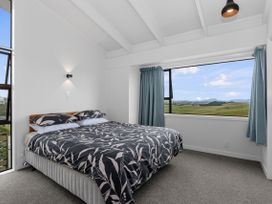 A bedroom with a bed and a window at Mania Views Waipu