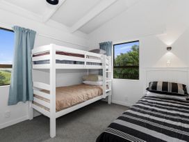 A bedroom with a bunk bed and a single bed at Mania Views Waipu