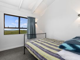 A bedroom with a bed and window at Mania Views Waipu