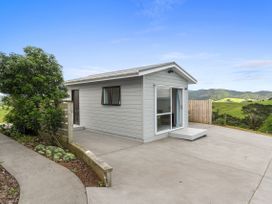 A building with a concrete patio and landscaped area at Mania Views Waipu