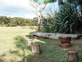 A garden with wooden stools and a fire pit at Mangawhai Heads in Mangawhai Heads
