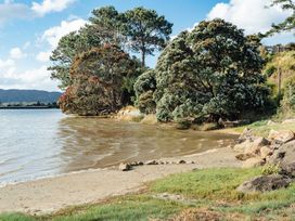 A beach with water and trees at Mangawhai Heads