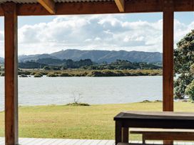 A view of water and mountains from a wooden structure at Mangawhai Heads