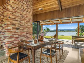 A dining room with a table and chairs at Mangawhai Heads