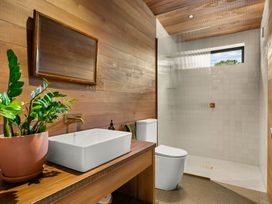 A bathroom with a sink, toilet, and shower at Mangawhai Heads