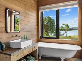 A bathroom with a bathtub and a vanity at Mangawhai Heads