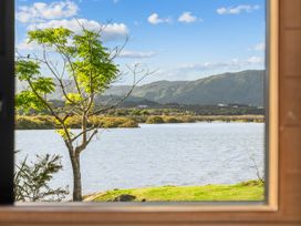 A view of a river and mountains from a window at Mangawhai Heads