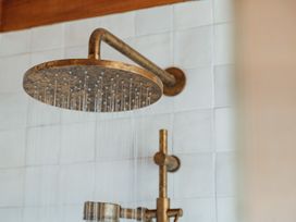 A shower head with water flowing at Mangawhai Heads