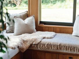 A snug with cushions and a blanket at Mangawhai Heads