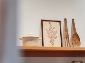 A cooking pot and wooden utensils on a shelf at Mangawhai Heads