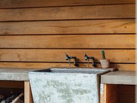A sink with faucets and a cactus at Mangawhai Heads