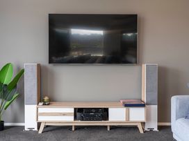 A living room with a television on a media console in Motuoapa Holiday Home Motuoapa