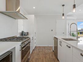 A kitchen with stove, sink and dishwasher at Motuoapa Holiday Home in Motuoapa
